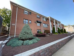Irvington apartment for rent - A red brick building with a green tree in front.