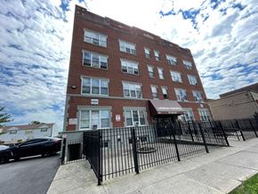 East Orange apartment for rent - A red brick building with a black fence in front.