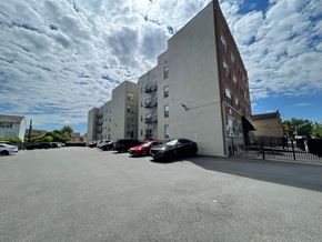 East Orange apartment for rent - A parking lot with cars and a building in the background.