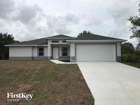 Fort Myers house for rent - a white house with a yard and a driveway