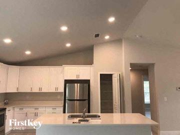 Fort Myers house for rent - a kitchen with white cabinets and a sink and a refrigerator