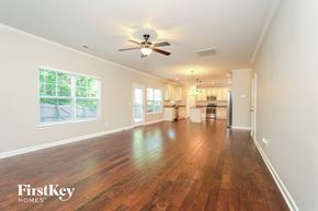 Kernersville house for rent - A spacious room with wooden floors and a ceiling fan.