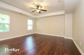 Kernersville house for rent - A room with wooden floors and a ceiling fan.