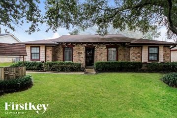 Friendswood house for rent - an old brick house with a lawn and a tree