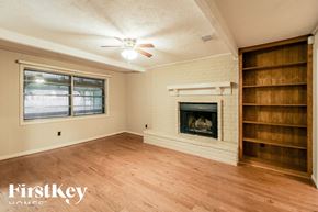 Friendswood house for rent - a living room with a brick fireplace and wooden shelves