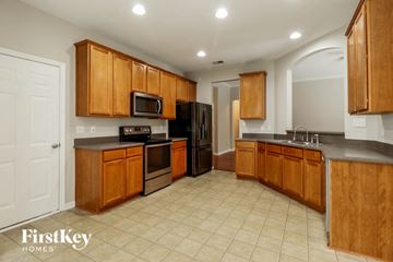 Summerville house for rent - a kitchen with wooden cabinets and black appliances