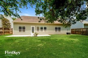 Summerville house for rent - a white house with a grassy yard and a wood fence