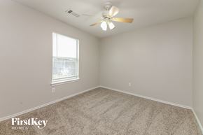 Forney house for rent - a bedroom with carpet and a ceiling fan and a window