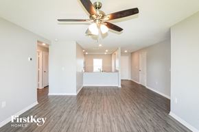 Leesburg house for rent - A spacious room with a ceiling fan and wooden flooring.