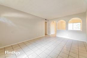 Garland house for rent - A spacious room with arched windows and tiled flooring.