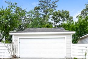 Humble house for rent - a white garage with a gray roof in front of trees