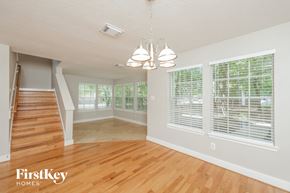 Humble house for rent - an empty living room with a hardwood floor and large windows