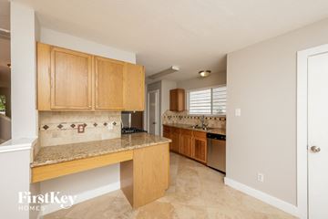Humble house for rent - a kitchen with wooden cabinets and a counter top