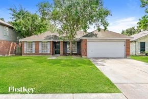 Katy house for rent - a brick house with a lawn and a white garage door