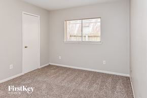 Katy house for rent - a bedroom with carpet and a window and a door
