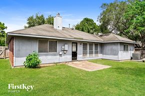 Katy house for rent - a small gray house with a yard and grass
