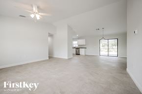 Lehigh Acres house for rent - an empty living room with white walls and a ceiling fan