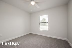 Lehigh Acres house for rent - a bedroom with a ceiling fan and a window
