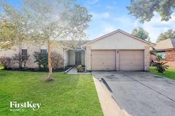 Houston house for rent - a house with a driveway and a garage door