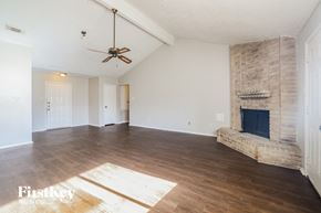 Houston house for rent - a living room with a fireplace and a ceiling fan