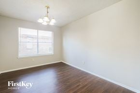 Houston house for rent - a bedroom with white walls and wood floors and a window