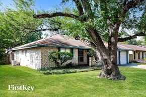 Spring house for rent - A tree in front of a house with the words "FirstKey Homes" on the bottom left.