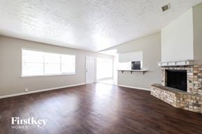 Spring house for rent - A room with a stone fireplace and wooden floors.