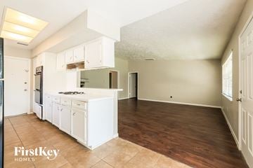 Spring house for rent - A kitchen with white cabinets and a wooden floor.