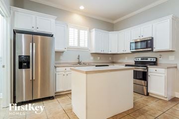 Helena house for rent - a white kitchen with stainless steel appliances and white cabinets