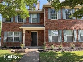Rockwall house for rent - A brick house with a black door and windows.