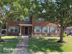 Rockwall house for rent - A brick house with a tree in front of it.