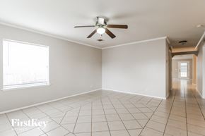 Tomball house for rent - A spacious room with a ceiling fan and tiled flooring.