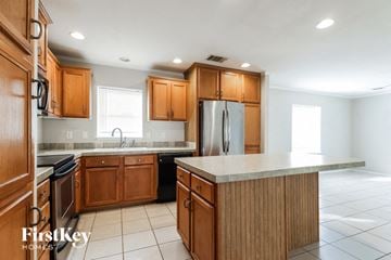 Tomball house for rent - A kitchen with wooden cabinets and a refrigerator.