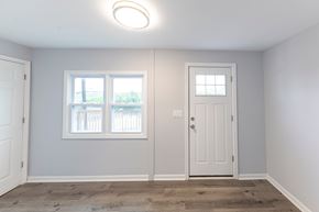 Rosedale apartment for rent - A room with a white door and a window with a view of a fence and trees.