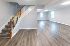 Rosedale apartment for rent - A spacious room with wooden floors and a staircase with a wooden banister.