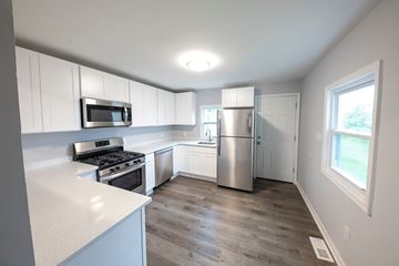 Rosedale apartment for rent - A kitchen with white cabinets and a stainless steel refrigerator.