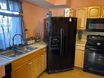 Chester apartment for rent - A black refrigerator in a kitchen with wooden cabinets.