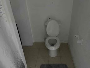 Chester apartment for rent - A toilet in a small bathroom with a mat on the floor.