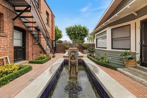 Fullerton apartment for rent - A brick building with a fountain in the middle of a walkway.