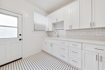 Fullerton apartment for rent - A kitchen with white cabinets and a black and white floor.