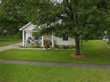 Warren house for rent - A small white house with a porch and a tree in front.