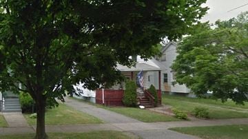 Warren house for rent - A house with a flag on the front porch is surrounded by trees.
