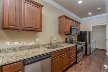 Durant apartment for rent - A kitchen with brown cabinets and granite countertops.