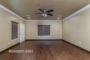 Durant apartment for rent - A room with a ceiling fan and wooden flooring.