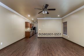 Durant apartment for rent - A spacious room with a ceiling fan and wooden flooring.