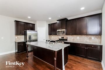 Villa Rica house for rent - a kitchen with black cabinets and a marble counter top