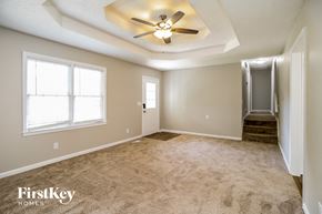 Canton house for rent - an empty living room with a ceiling fan and a door