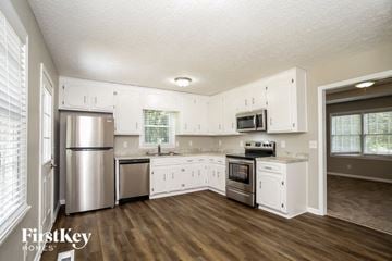 Canton house for rent - a kitchen with white cabinets and stainless steel appliances