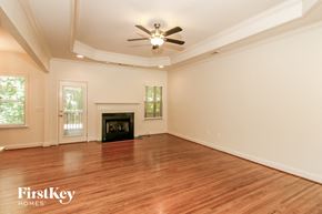 Chelsea house for rent - A spacious room with a fireplace and a ceiling fan.