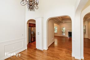 Chelsea house for rent - A large open room with arched doorways and a chandelier.
